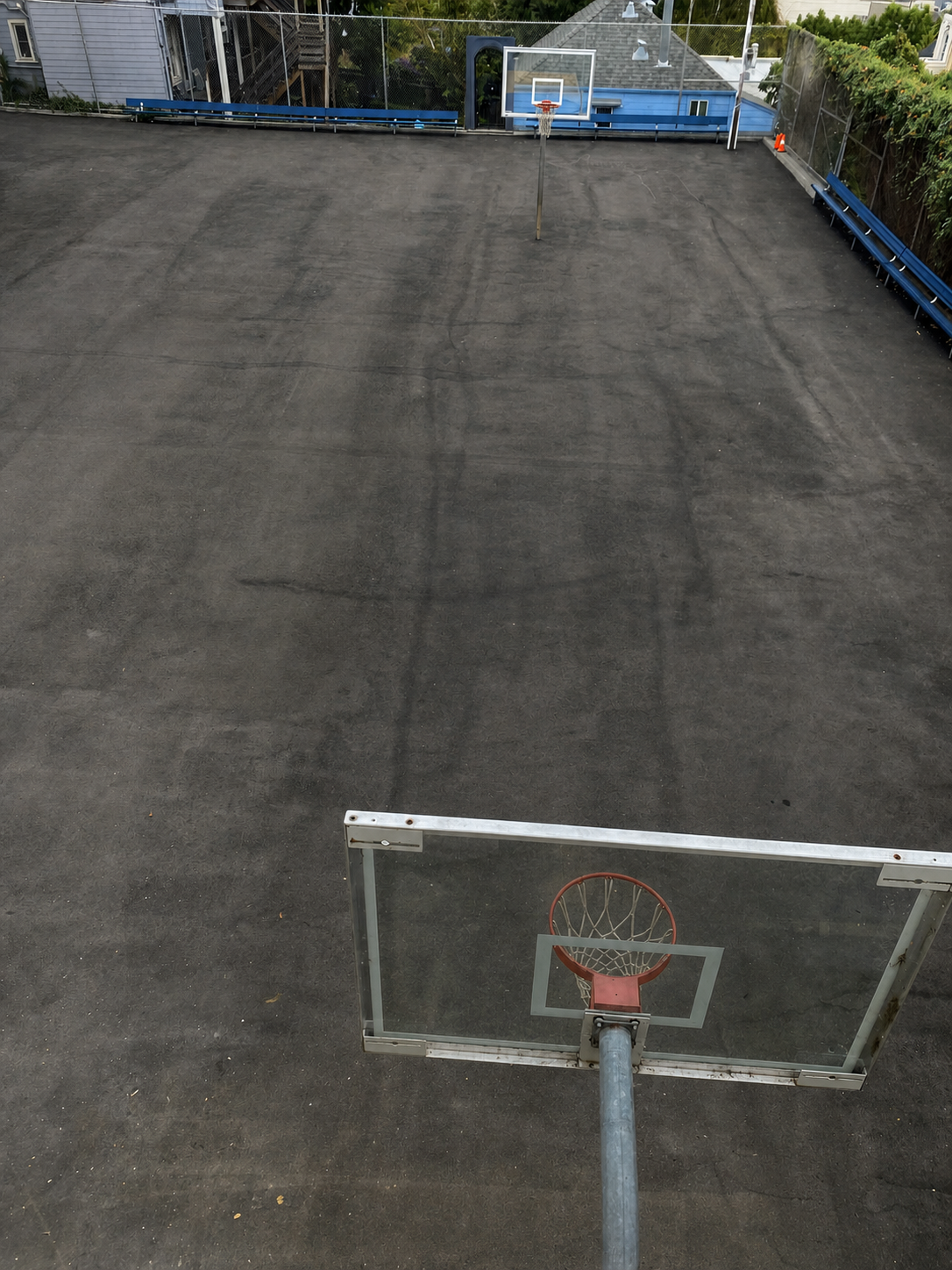 Before: plain worn asphalt basketball court at a church school